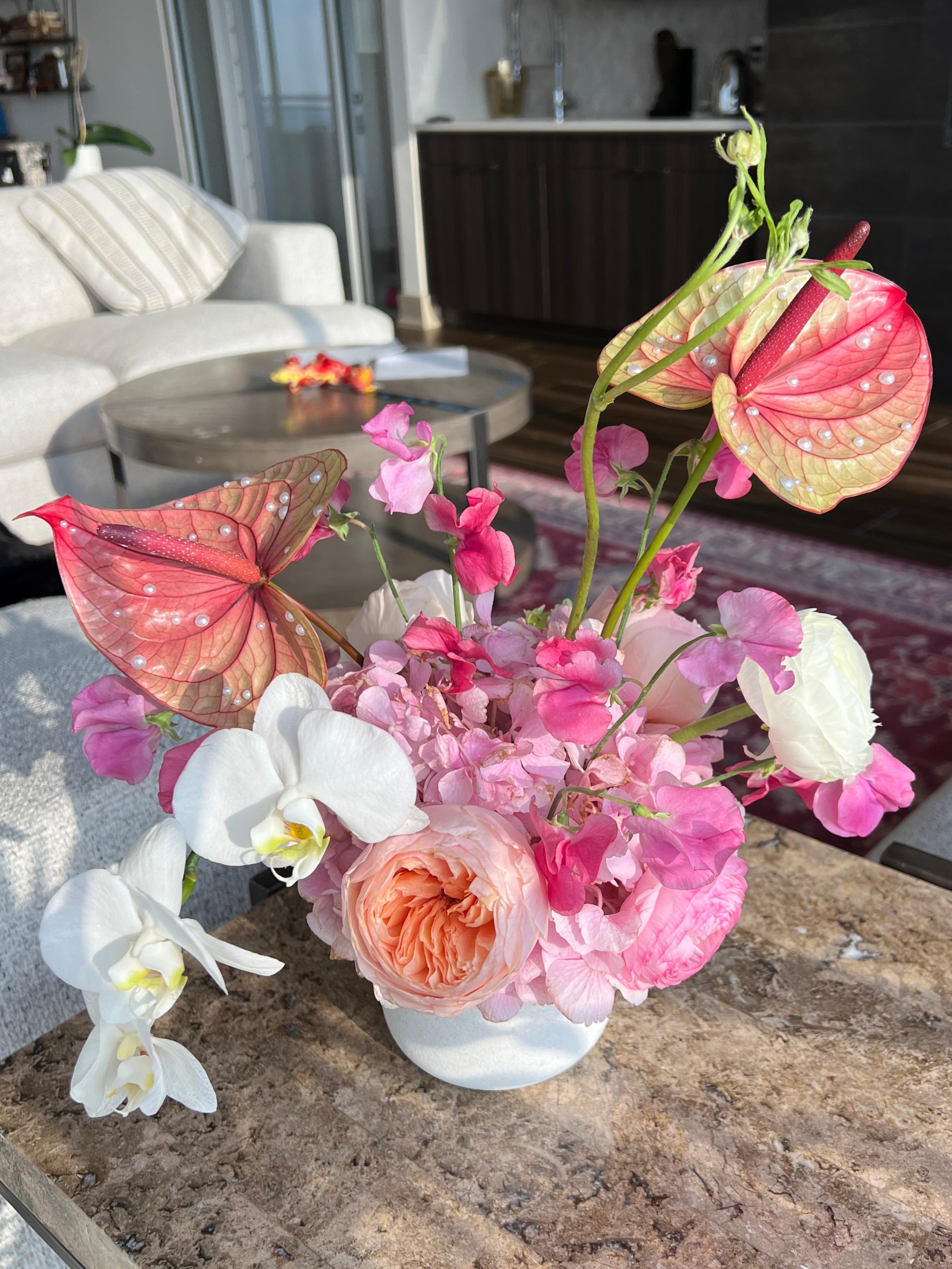 Premium floral arrangement with pink, white, and peach flowers on a stone surface.